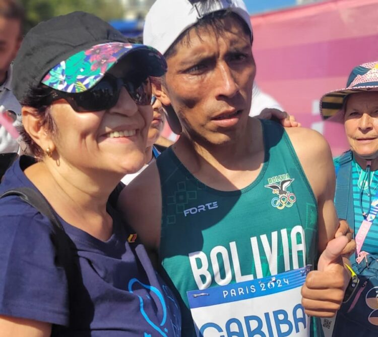 Héctor Garibay junto a una residente boliviana en París, quien le pidió una fotografía