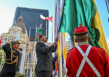 El presidente Luis Arce iza la bandera en los mástiles de la plaza Murillo, este sábado en La Paz.