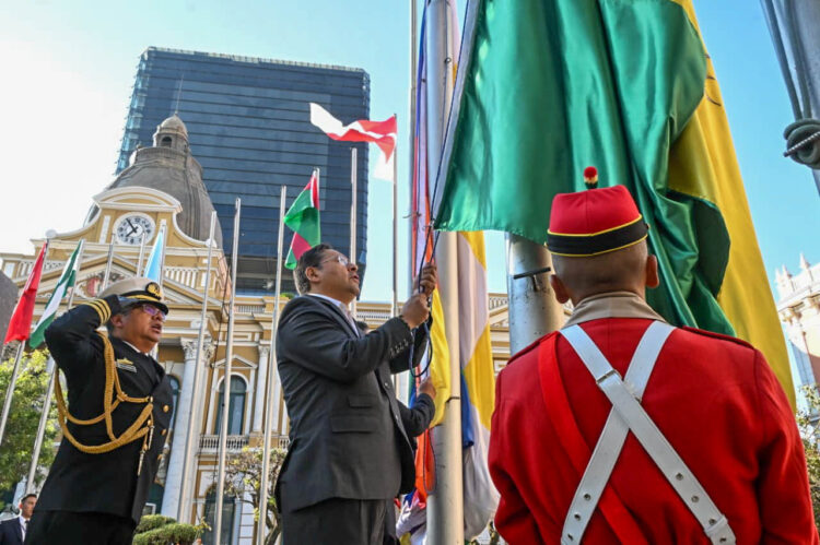 El presidente Luis Arce iza la bandera en los mástiles de la plaza Murillo, este sábado en La Paz.