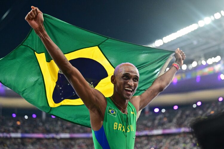 El brasileño Alison Dos Santos festeja con su bandera.