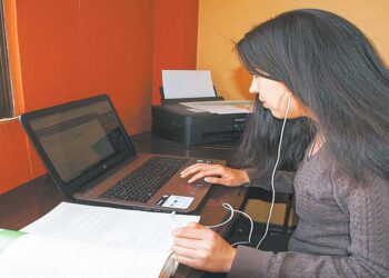 Una joven cumple sus actividades en la modalidad de teletrabajo desde su domicilio.