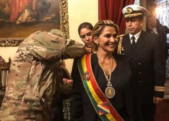 Una militar impone los símbolos presidenciales a Jeanine Áñez, en el Palacio Quemado, en 2019.