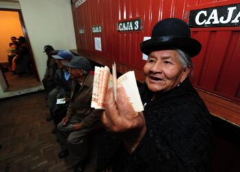 Una adulta mayor muestra el dinero cobrado de su Renta Dignidad.