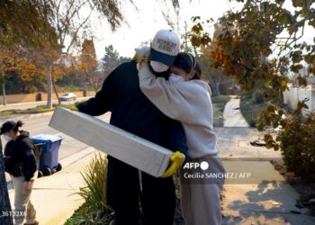 Una pareja observa lo único que quedó de su casa