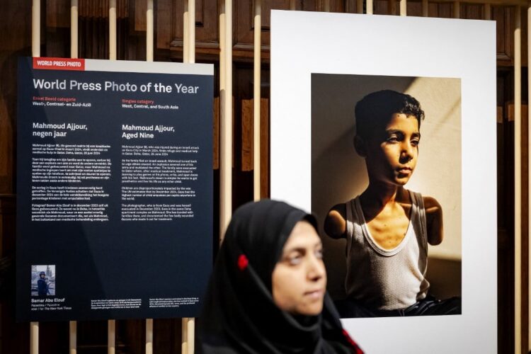 La fotógrafa palestina Samar Abu Elouf posa junto a su foto