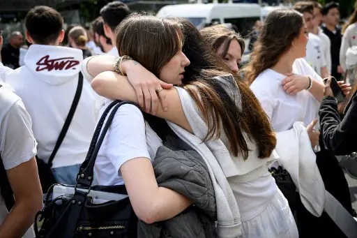 Los compañeros de la fallecida colocaron flores en la puerta de su colegio