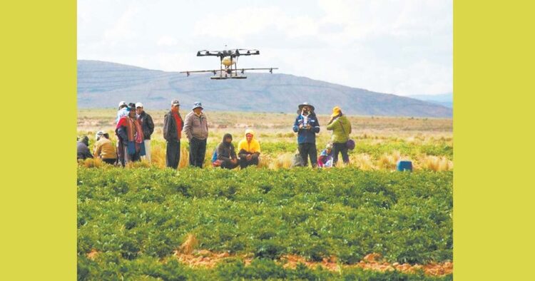 Comunarios utilizando un dron especializado para mejorar los resultados de sus cultivos.