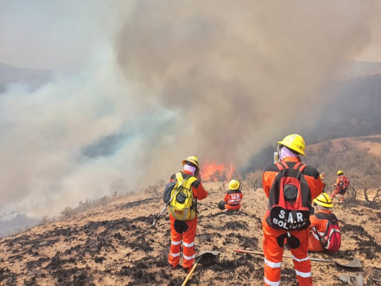 Bomberos sofocan incendios en Cochabamba, este jueves.