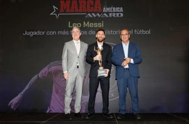 Lionel Messi con su galardón y el directo y ejecutivo del periódico español  Marca