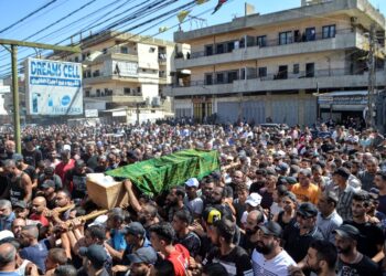 Una muntitudinaria concentración lleva uno de los cuerpos recuperados del naufragio. Foto: AFP