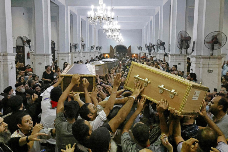 Portadores de los féretros se abrieron camino entre la multitud de dolientes que intentaban tocar los ataúdes. Foto: AFP