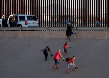 Una familia de migrantes intenta cruzar la frontera. Foto: AFP