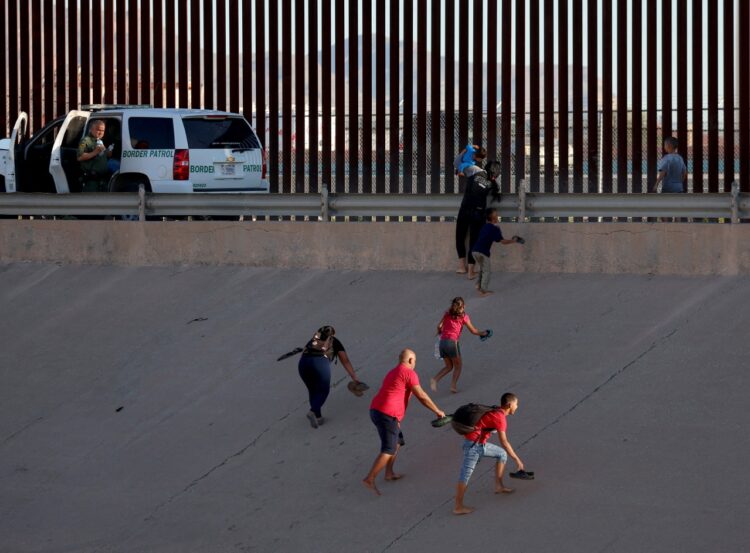 Una familia de migrantes intenta cruzar la frontera. Foto: AFP