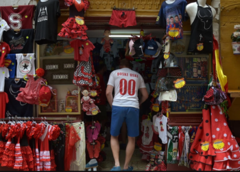 Un cliente accede a una tienda de regalos de la ciudad española de Sevilla. Foto: AFP.
