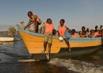 Niños de Bahía El Molo bajan de una lancha para ir a la escuela en el norte de Kenia. Foto: AFP.