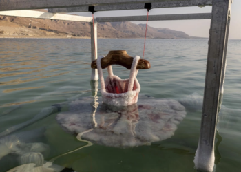 Un vestido de bailarina es sumergido en el mar Muerto por la artista israelí Sigalit Landau. Foto: AFP.