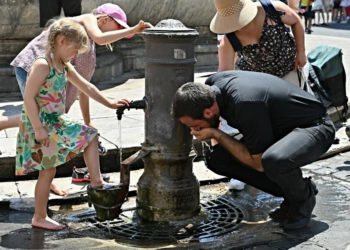 Turistas se refrescan y beben en una fuente frente al Panteón, en medio de una feroz ola de calor que arrasa Europa, en el centro de Roma. Foto: AFP.