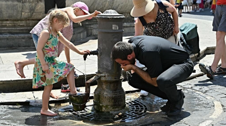Turistas se refrescan y beben en una fuente frente al Panteón, en medio de una feroz ola de calor que arrasa Europa, en el centro de Roma. Foto: AFP.