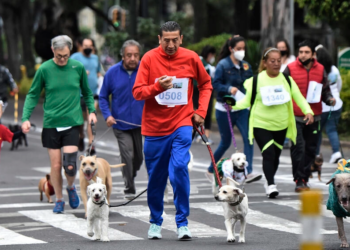 Personas con sus perros participan en la carrera "Perritos en fuga", en Ciudad de México, el 11 de septiembre de 2022. Foto: AFP.