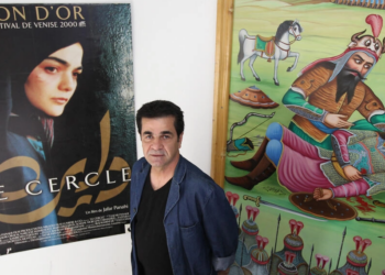 El director de cine iraní Jafar Panahi, junto a un cartel de su película 'El círculo'. Foto: AFP.