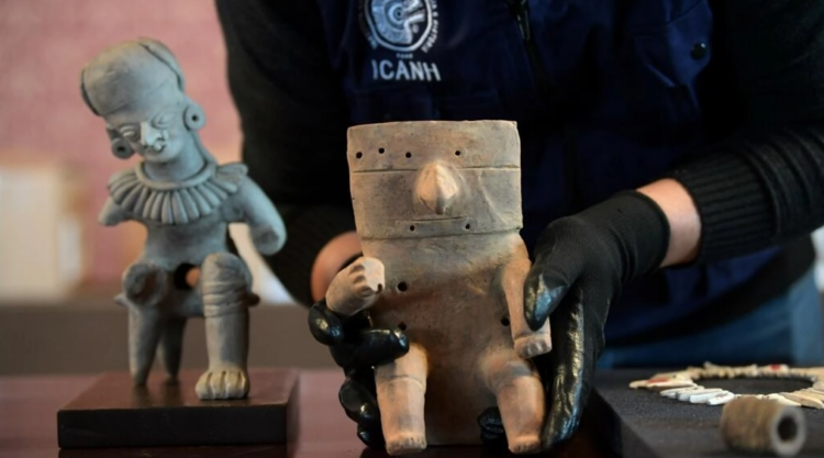 Un miembro del Instituto Colombiano de Antropología e Historia exhibe piezas precolombinas en Bogotá, el 26 de septiembre de 2022. Foto: AFP.