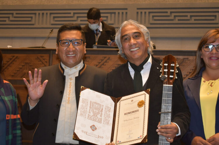 El artista Willy Claure (der) recibe un reconocimiento del presidente de la Cámara de Diputados, Freddy Mamani. Foto: Cámara de Diputados.