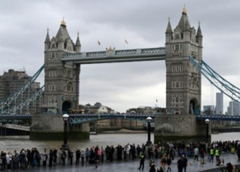 Una fila de personas espera su turno para visitar la capilla ardiente de la reina Isabel II el 15 de septiembe de 2022 junto al Puente de Londres. Foto: AFP.