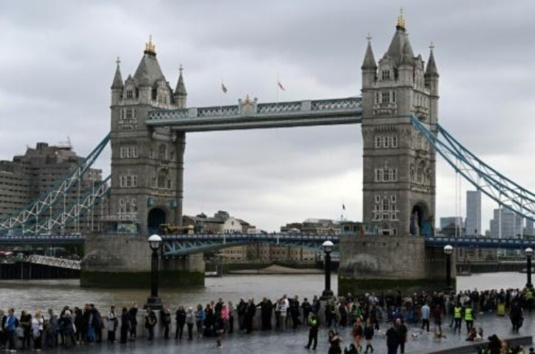 Una fila de personas espera su turno para visitar la capilla ardiente de la reina Isabel II el 15 de septiembe de 2022 junto al Puente de Londres. Foto: AFP.