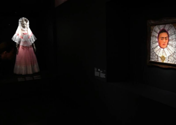 Un autorretrato de la pintora mexicana Frida Kahlo, ataviada con un resplandor, tocado de origen religioso, frente a un traje indígena. Foto: AFP.