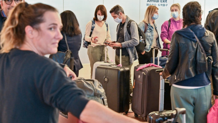 Unos turistas se congregan en la salida del aeropuerto Haneda de Tokio, Japón. Foto: AFP.