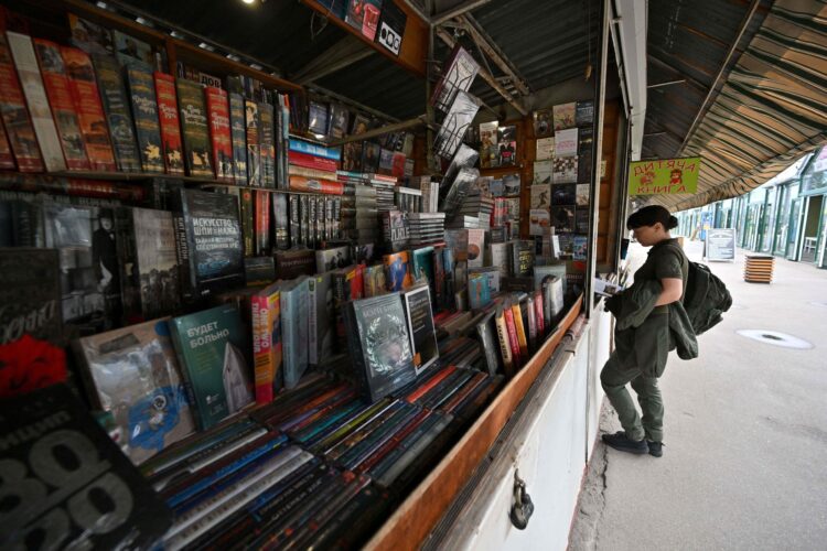 Un soldado ucraniano mira libros en el enorme mercado de libros de Petrivka en Kiev. Foto: AFP.