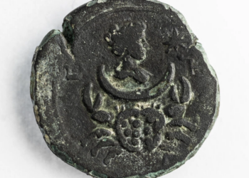 Una moneda de bronce de 1850 años, que representa a la diosa romana, Luna, en la Oficina de la Autoridad de Antigüedades de Israel. Foto: AFP.