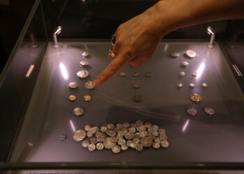 El arqueólogo Skender Mucaj muestra una concha que encontró en un agujero excavado por buscadores de tesoros ilegales en las ruinas de la Iglesia de Santa María en Brrar. Foto: AFP.