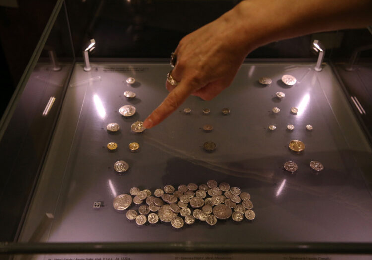 El arqueólogo Skender Mucaj muestra una concha que encontró en un agujero excavado por buscadores de tesoros ilegales en las ruinas de la Iglesia de Santa María en Brrar. Foto: AFP.