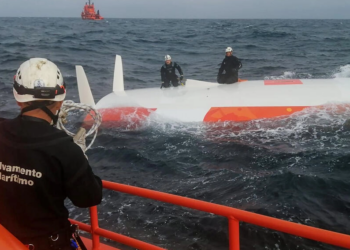 Rescatistas de pie sobre el casco del velero Jeanne Solo Sailor volcado, a 22 kilómetros de las costas de las islas Sisargas, en la región de Galicia, España. Foto: AFP.