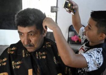 Eduardo Espinal, el niño de 12 años que se dedica a cortar el cabello. Foto: AFP.