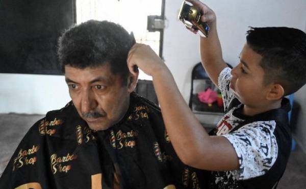 Eduardo Espinal, el niño de 12 años que se dedica a cortar el cabello. Foto: AFP.