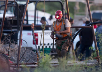Un rescatista trabaja en las inmediaciones de la mina inundada donde hay 10 obreros atrapados. Foto: AFP.