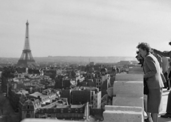 Algunos artistas inmigrantes contemplan una vista de París, con la Torre Eiffel al fondo, desde lo alto del Arco del Triunfo, una imagen tomada el 8 de abril del año 1950. Foto: AFP.