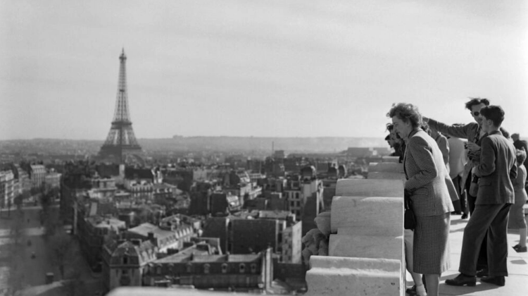 Algunos artistas inmigrantes contemplan una vista de París, con la Torre Eiffel al fondo, desde lo alto del Arco del Triunfo, una imagen tomada el 8 de abril del año 1950. Foto: AFP.
