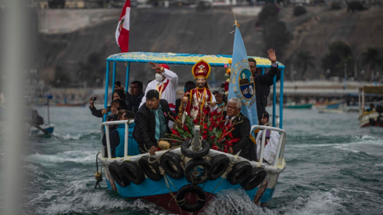 La imagen de San Pedro, patrón de los pescadores, es llevada en un barco durante una procesión en Lima el 29 de junio de 2022. Foto: AFP.