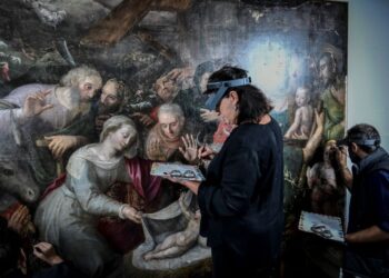 Artistas de renovación trabajan en una pintura en el sitio de restauración de pinturas de la catedral de Notre-Dame de París. Foto: AFP.