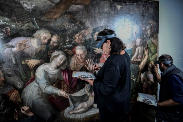 Artistas de renovación trabajan en una pintura en el sitio de restauración de pinturas de la catedral de Notre-Dame de París. Foto: AFP.