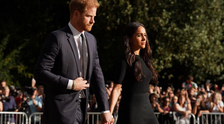 El príncipe Enrique y su esposa Meghan, llegan junto a los tributos florales en el camino al castillo de Windsor, el 10 de septiembre de 2022. Foto: AFP.