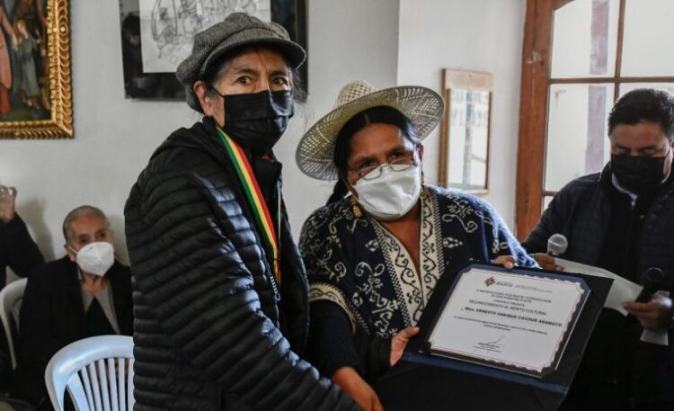 La viuda del maestro Cavour, María Antonieta Arauco, recibe la distinción de parte de la ministra de Culturas, Sabina Orellana. Foto: Ministerio de Culturas.