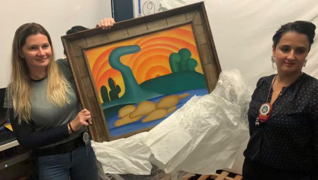 Policías sostienen la pintura 'Sol Poente' de la artista brasileña Tarsila do Amaral. Foto: AFP.