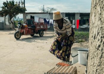 Danai Bvochora prepara los huevos que llevará al mercado utilizando su triciclo eléctrico. Foto: AFP.
