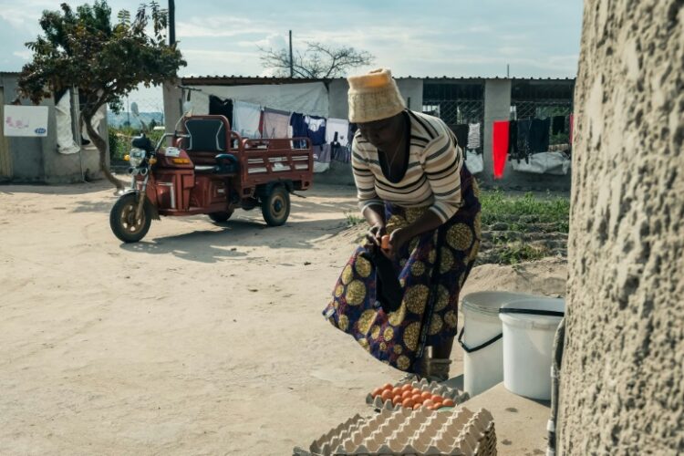 Danai Bvochora prepara los huevos que llevará al mercado utilizando su triciclo eléctrico. Foto: AFP.