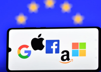 Los logotipos de los gigantes tecnológicos Google, Apple, Facebook, Amazon y Microsoft, fotografiados en la pantalla de un telófono móvil delante de una bandera de la Unión Europea. Foto: AFP.