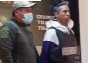 Un elemento de la Policía traslada al presunto autor del doble crimen. Foto: Captura BTV